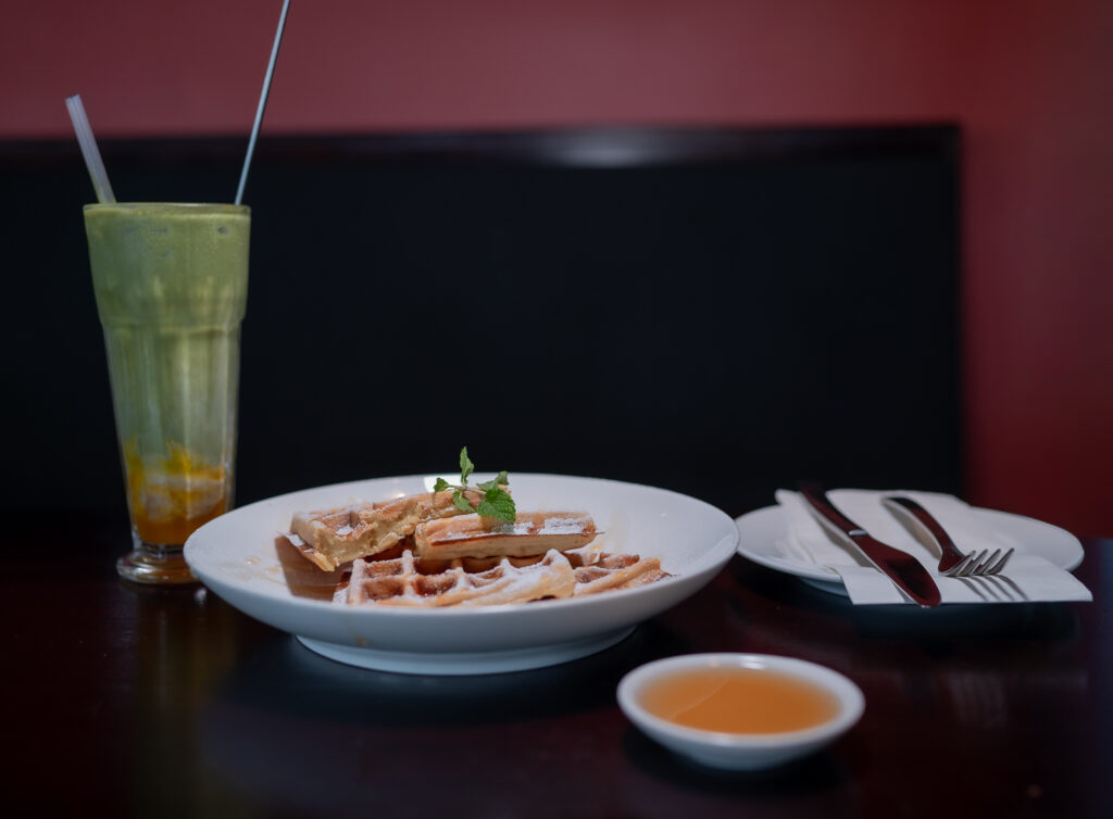 Waffles and a fresh smoothie in a cosy booth