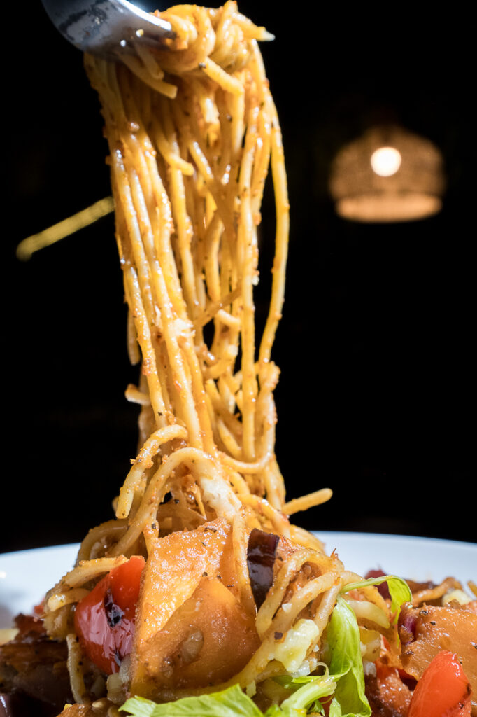 Spaghetti twirled high above the plate